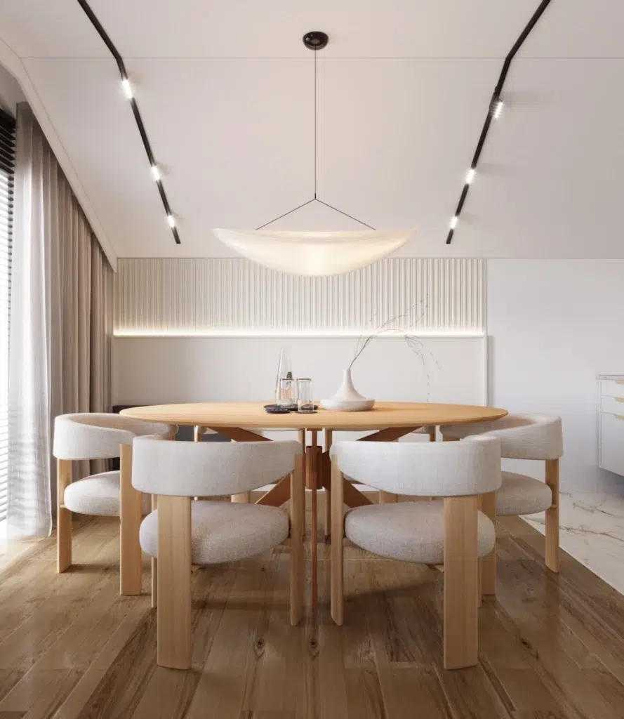 Nowoczesna jadalnia z okrągłym stołem i designerskimi krzesłami w jasnym, minimalistycznym wnętrzu kuchni